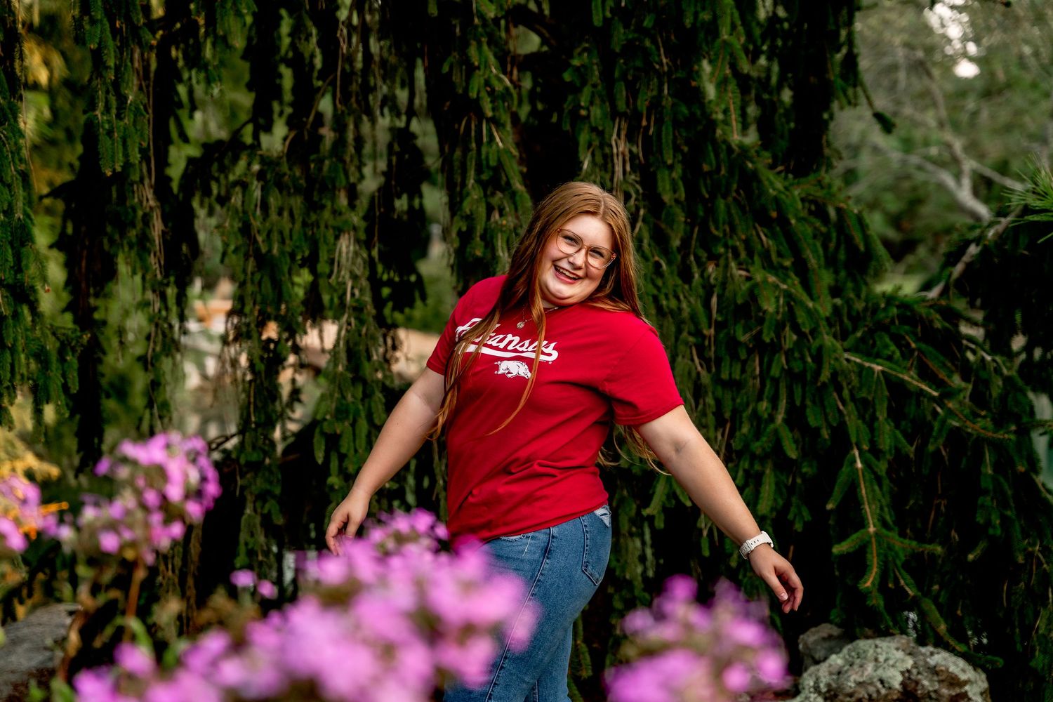 high school senior girl walking through the flowers