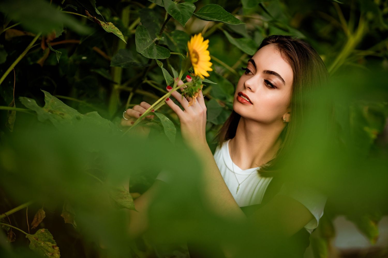 High School Senior Girl looking at sunflower