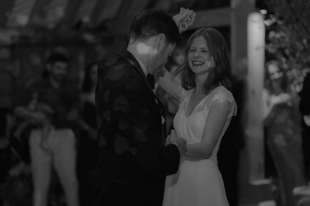 Bride and groom share romantic first dance in black and white wedding photography.