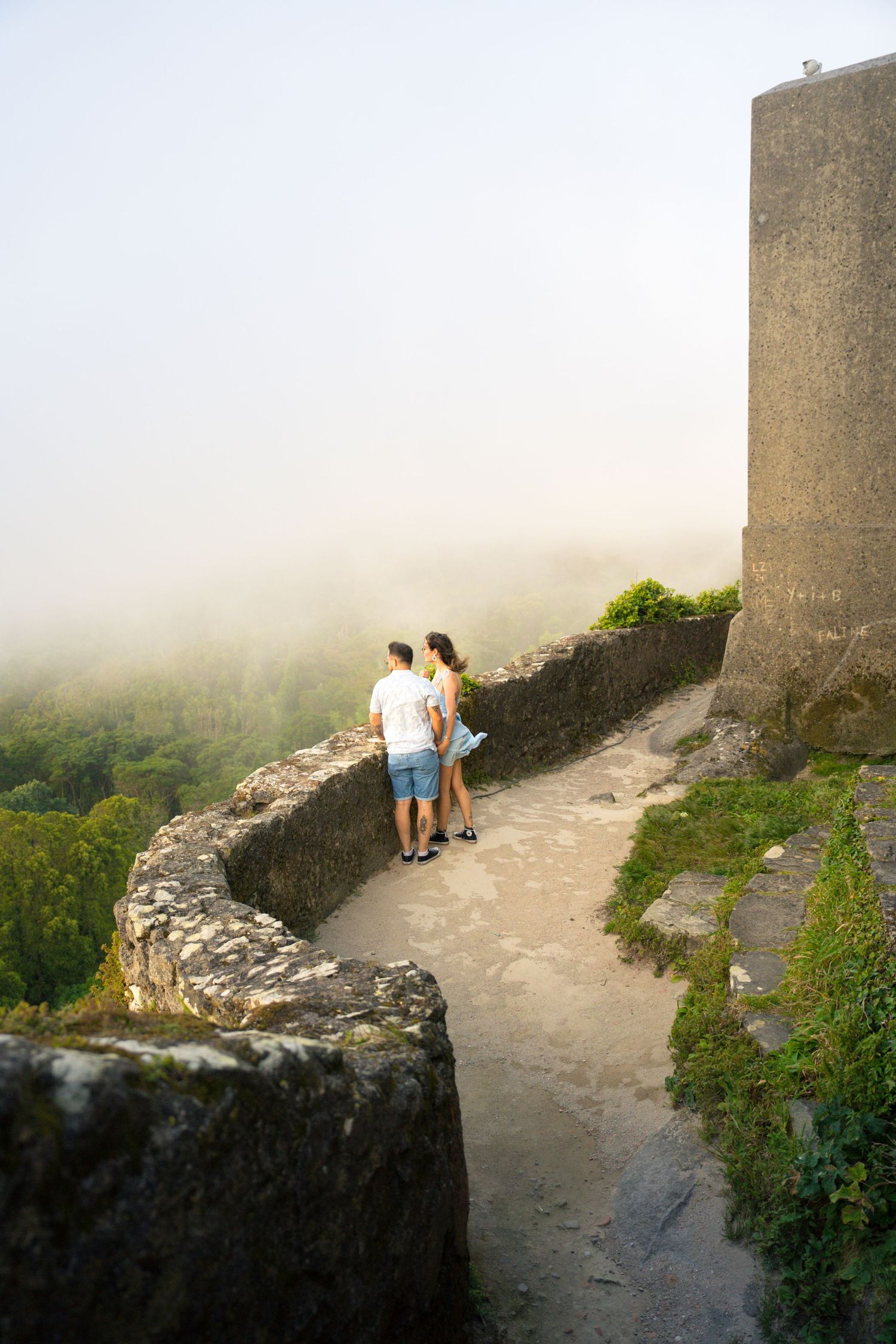 Historic castle walls and pathways shrouded in misty atmosphere.