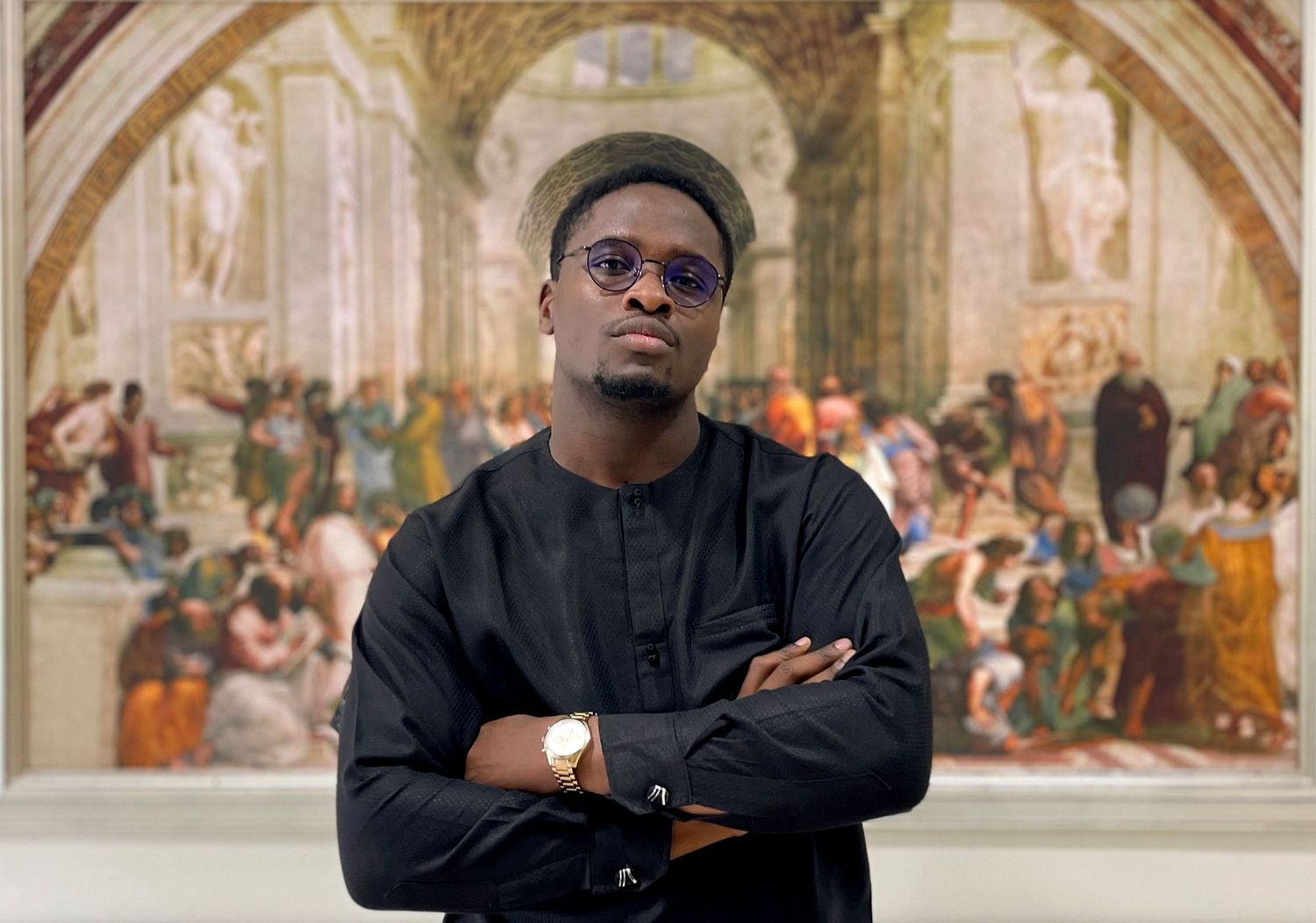 Stylish figure poses against ornate classical fresco background in all-black attire.