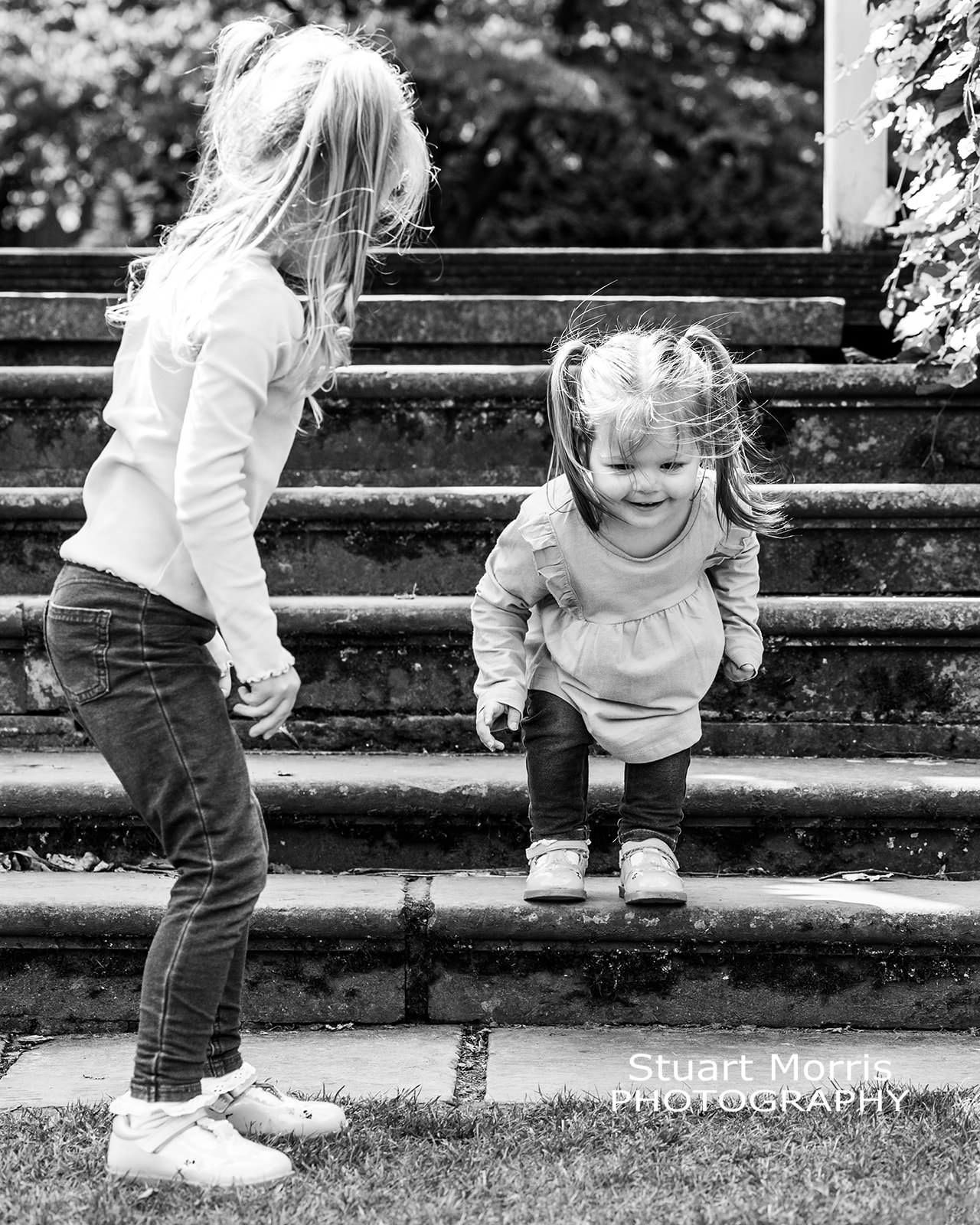 little girl gets ready to jump off a step. mini outdoor portrait session. Stuart Morris Photography.
