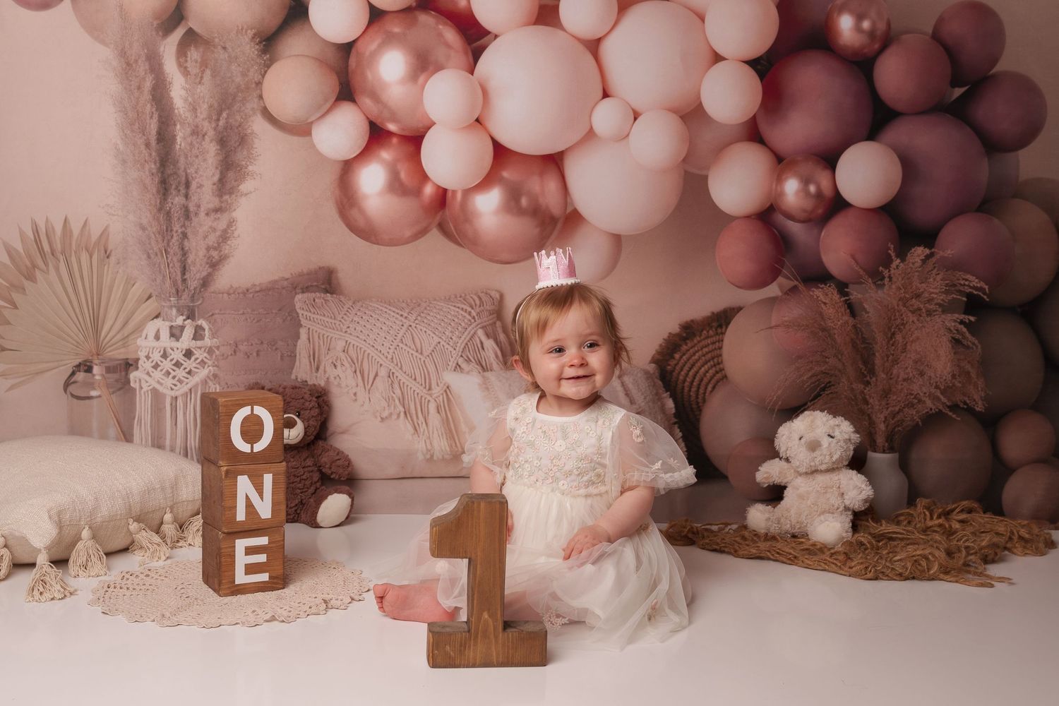 First birthday setup with number one prop and pink balloon arch.