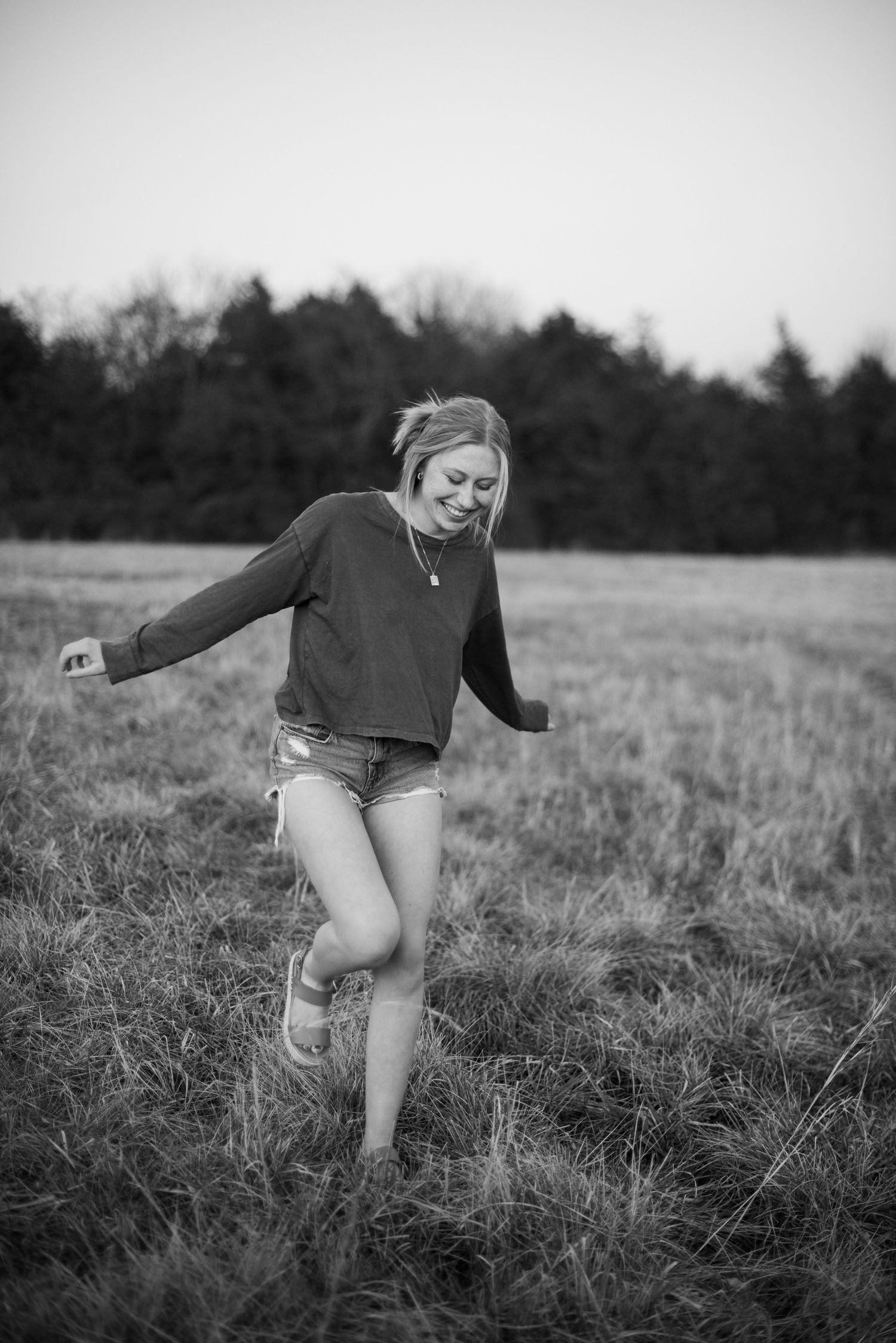 Black and white action shot of joyful movement in grassy field.