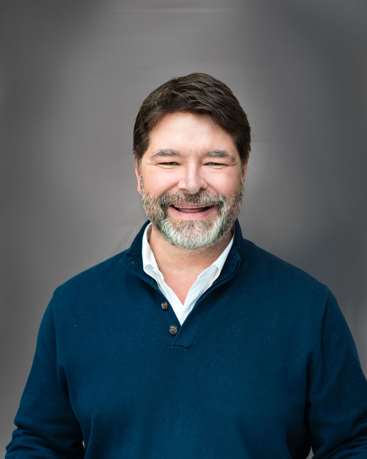 professional headshot of male teacher on grey background in Hilton Denver.