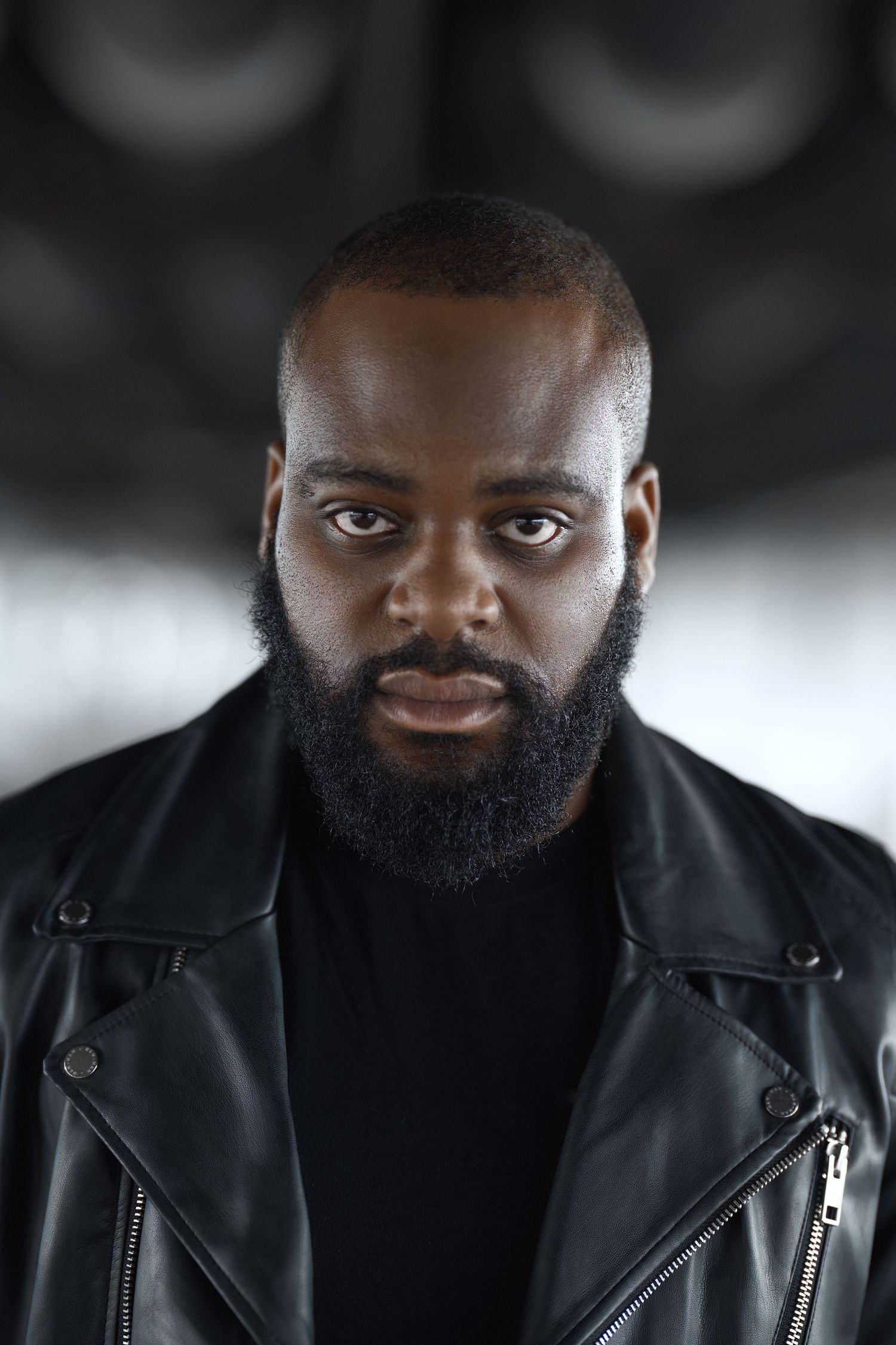 Studio portrait with dramatic lighting wearing black leather jacket.