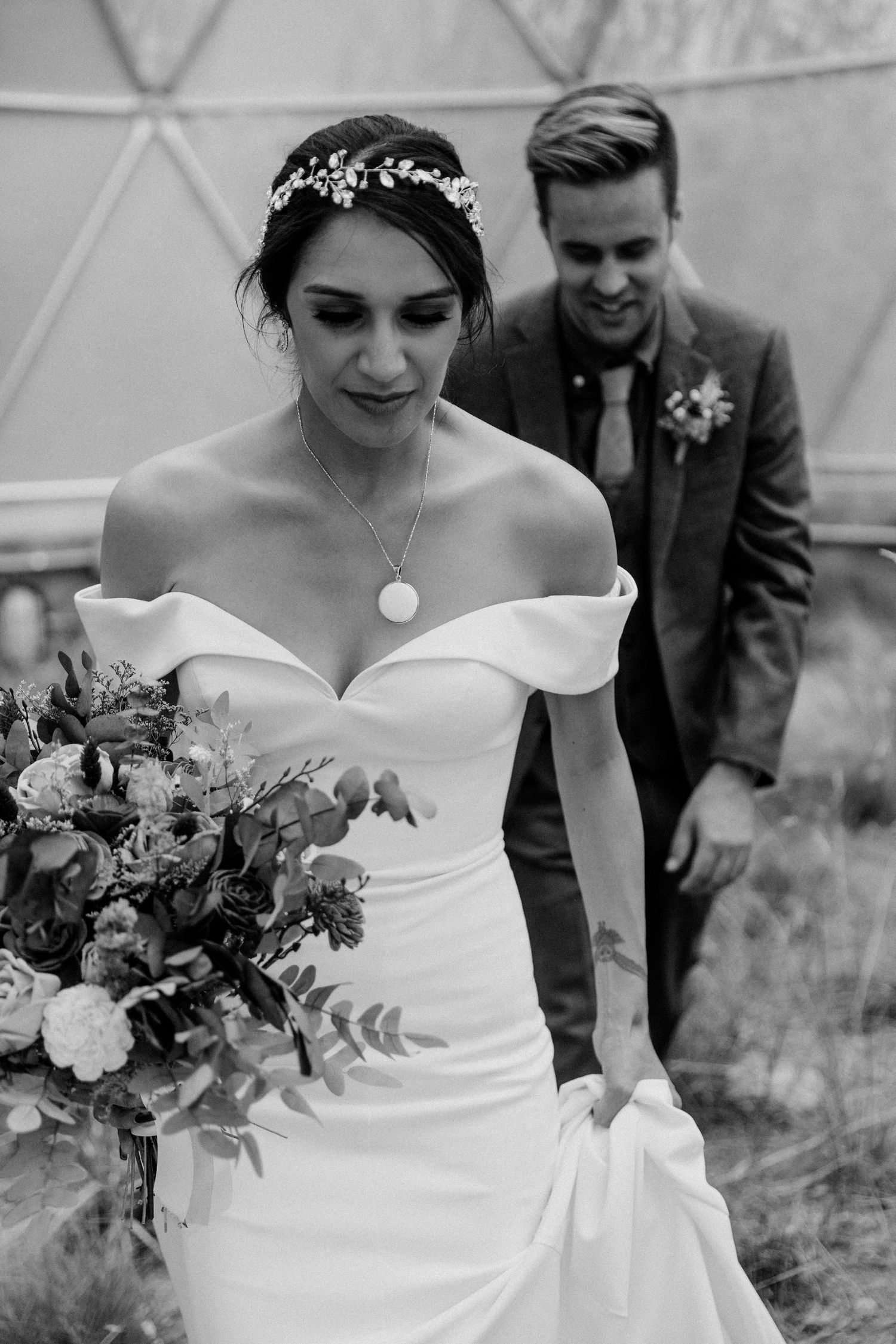 An elegant wedding portrait featuring a flowing white dress and floral bouquet.