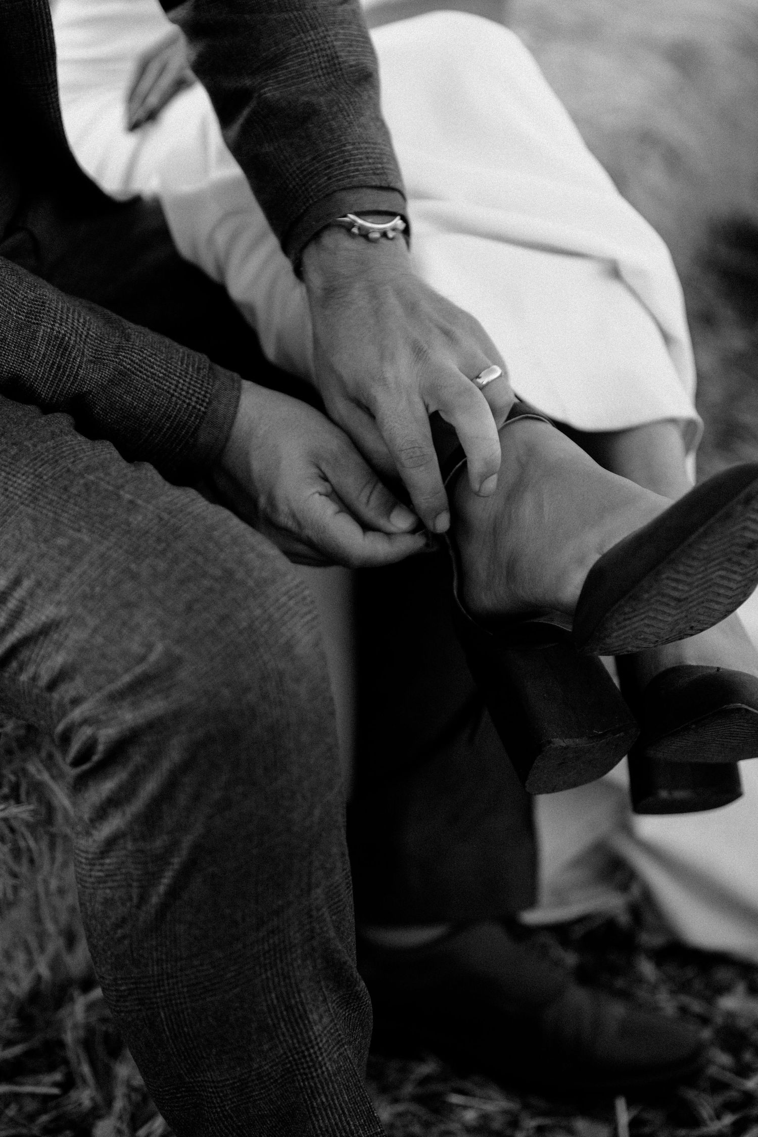 Close-up black and white photo of hands with wedding rings.