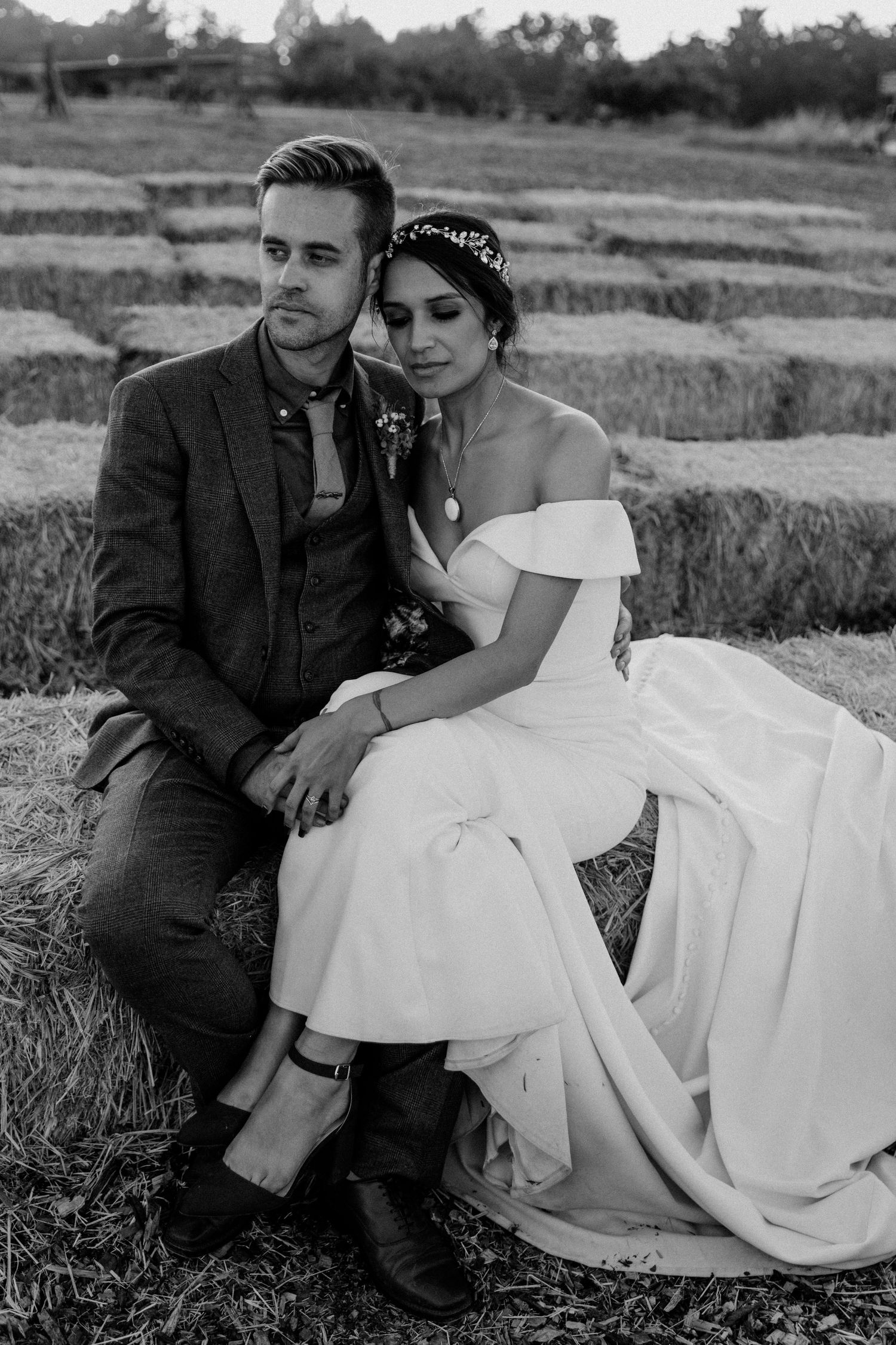 Black and white portrait of newlyweds sitting on terraced steps outdoors.