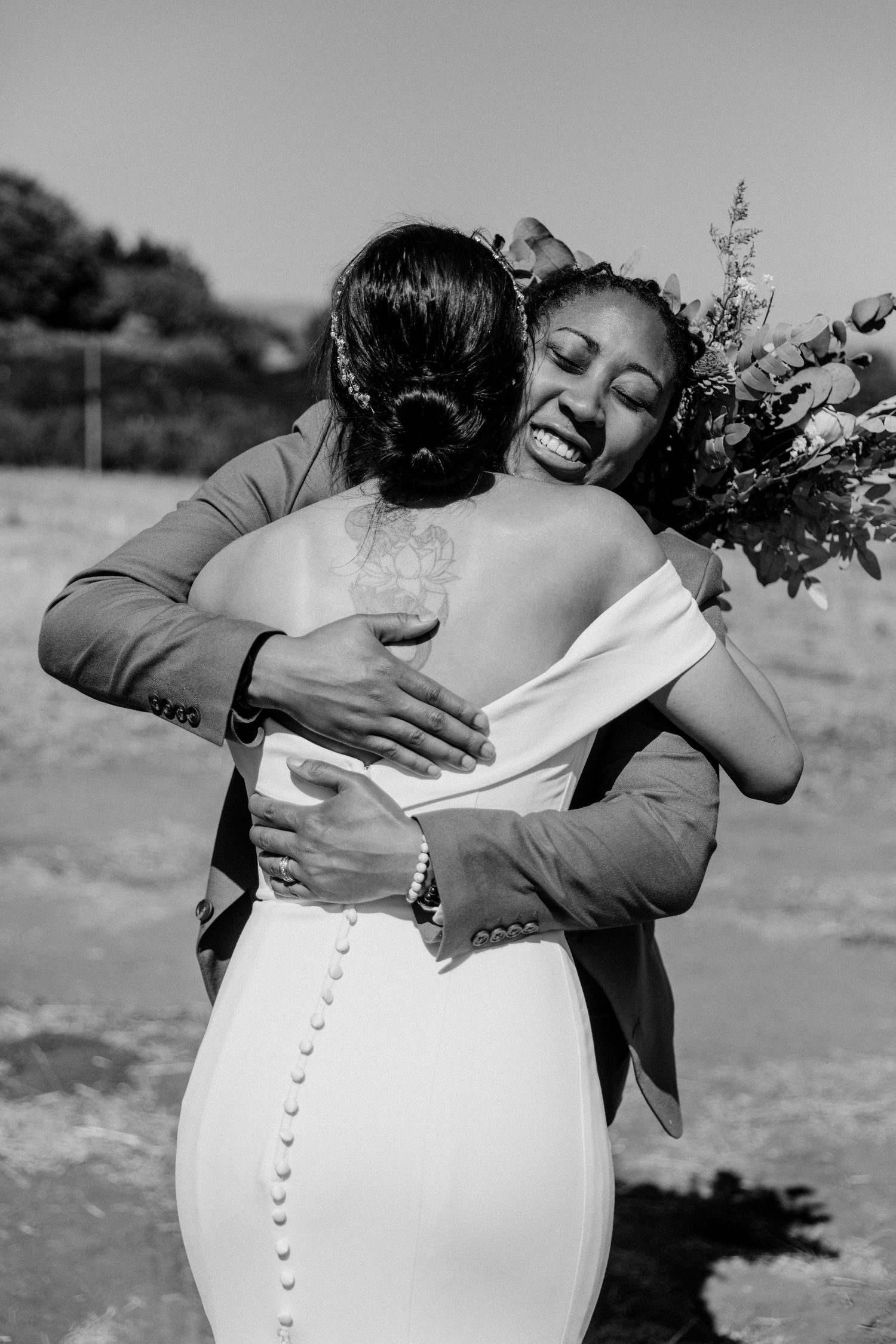 A touching black and white moment captured during a wedding celebration showing a warm embrace.
