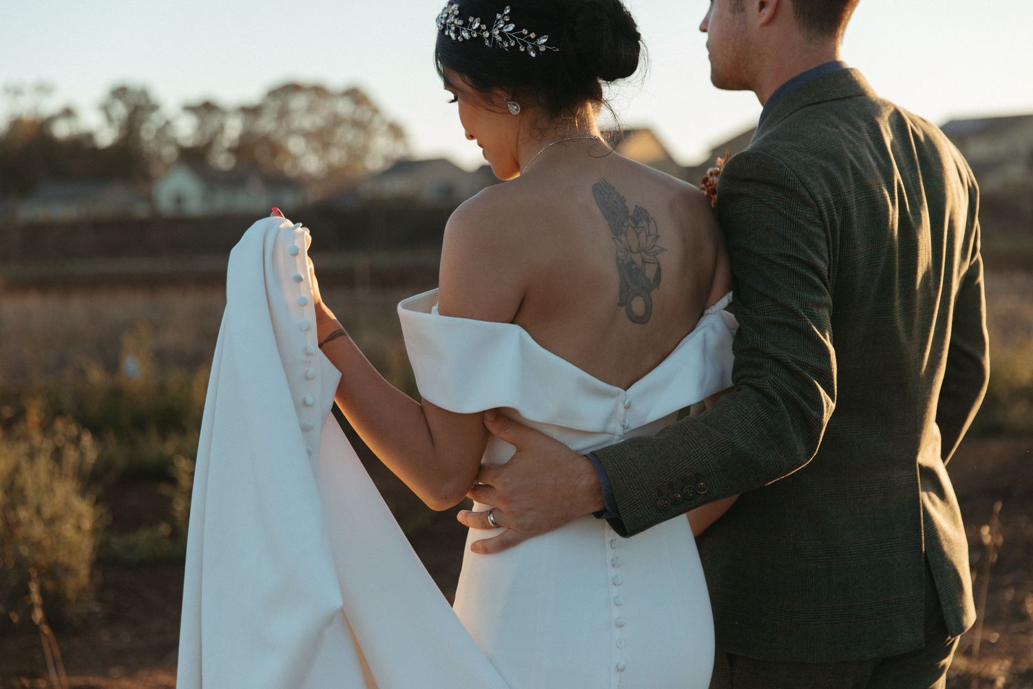 Wedding couple in an intimate outdoor moment as sun sets behind them.