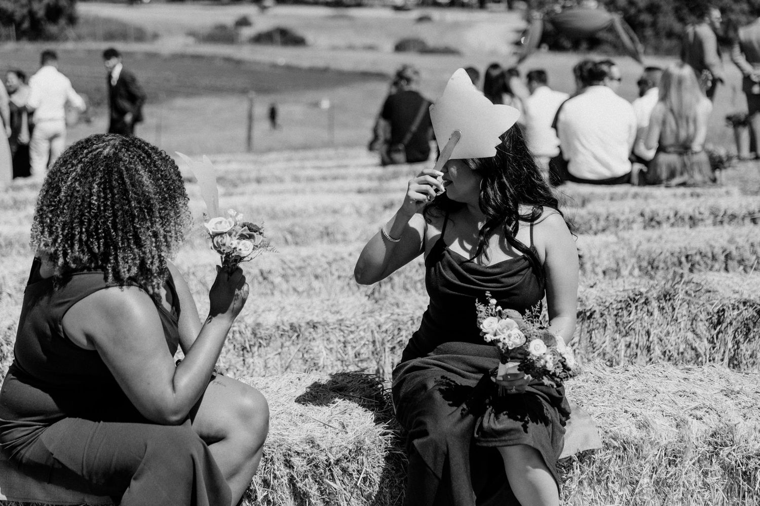 Black and white photo of guests enjoying drinks outdoors at a gathering.