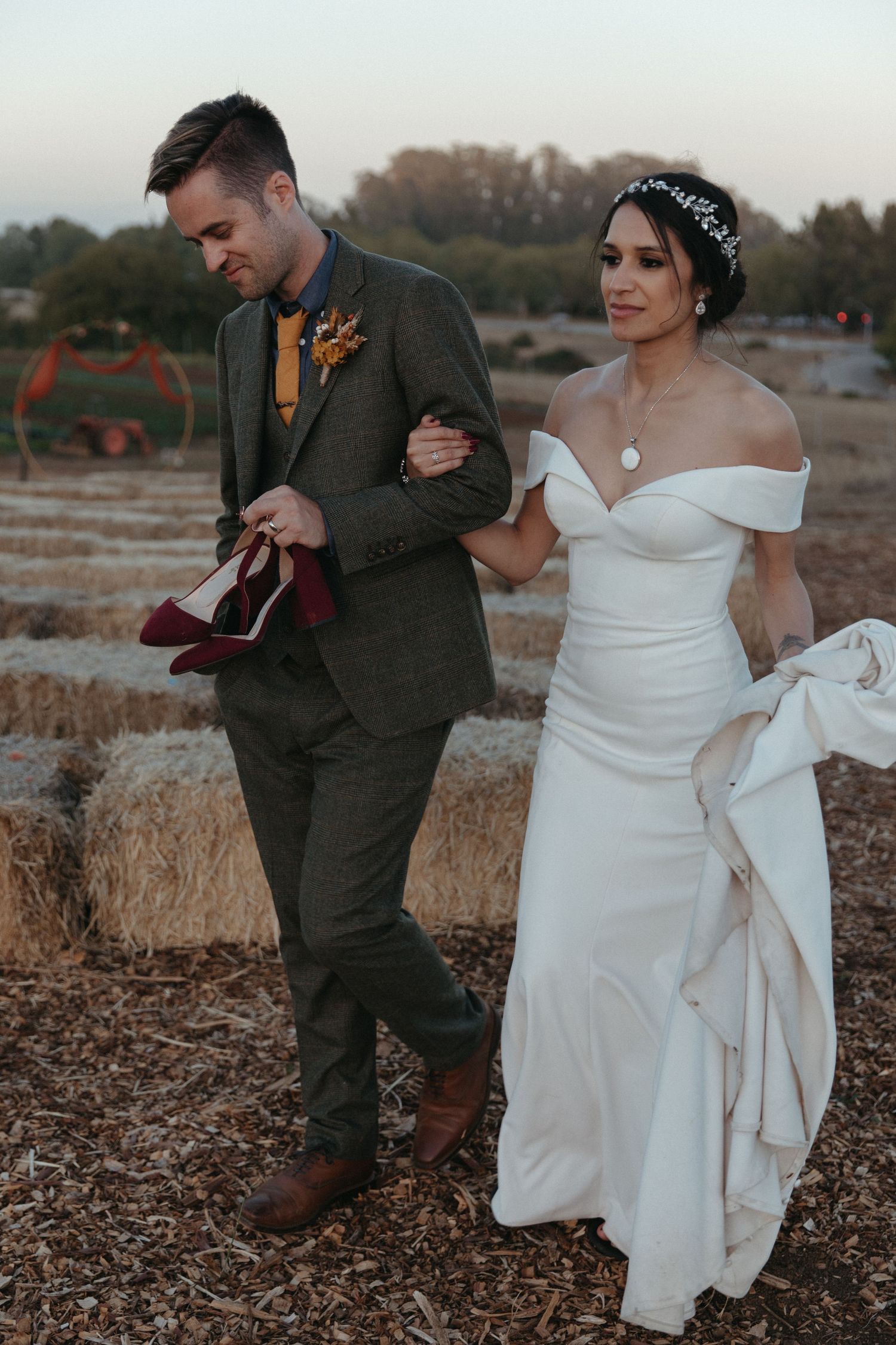 Wedding couple walking together on terraced landscape at sunset.