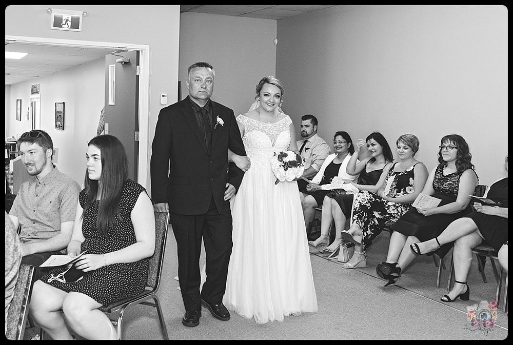 A wedding party waits in a hallway as preparations are underway before the ceremony.