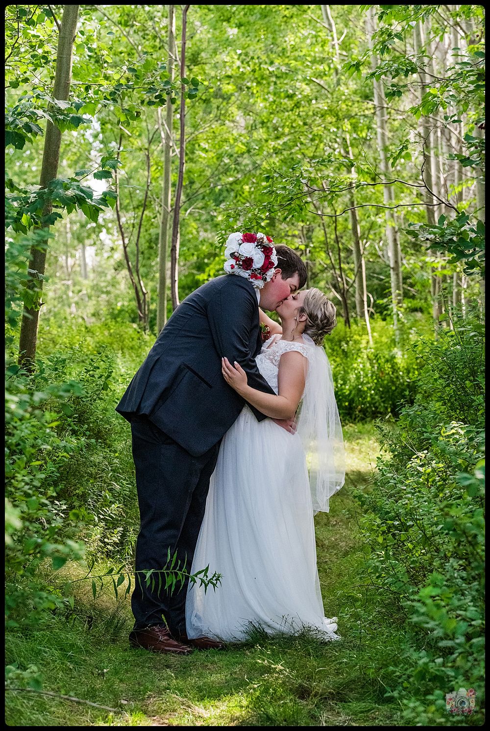 Romantic moment captured between couple in sunlit forest setting.
