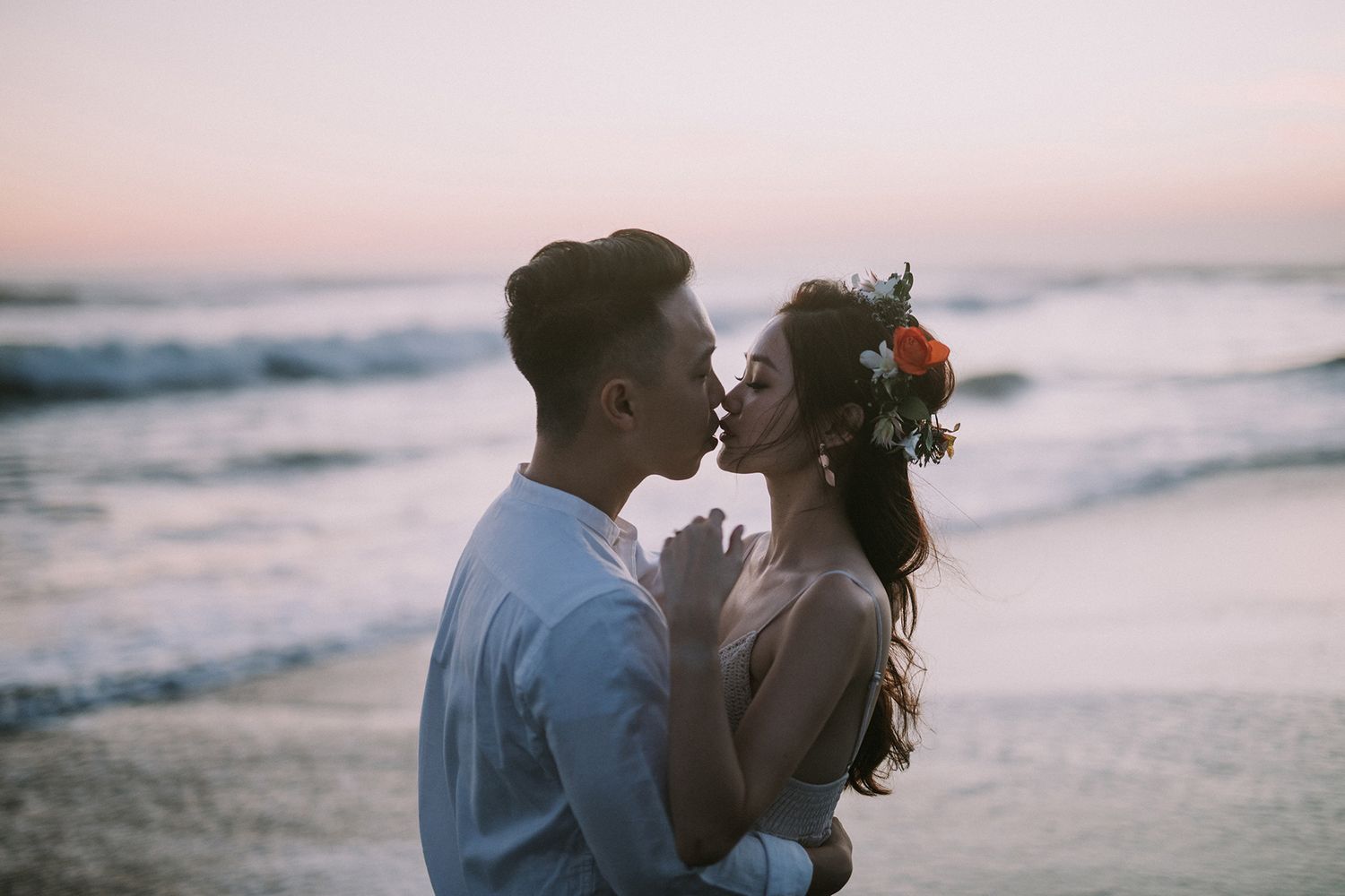 Intimate beachside moment captured during sunset with gentle waves rolling in.