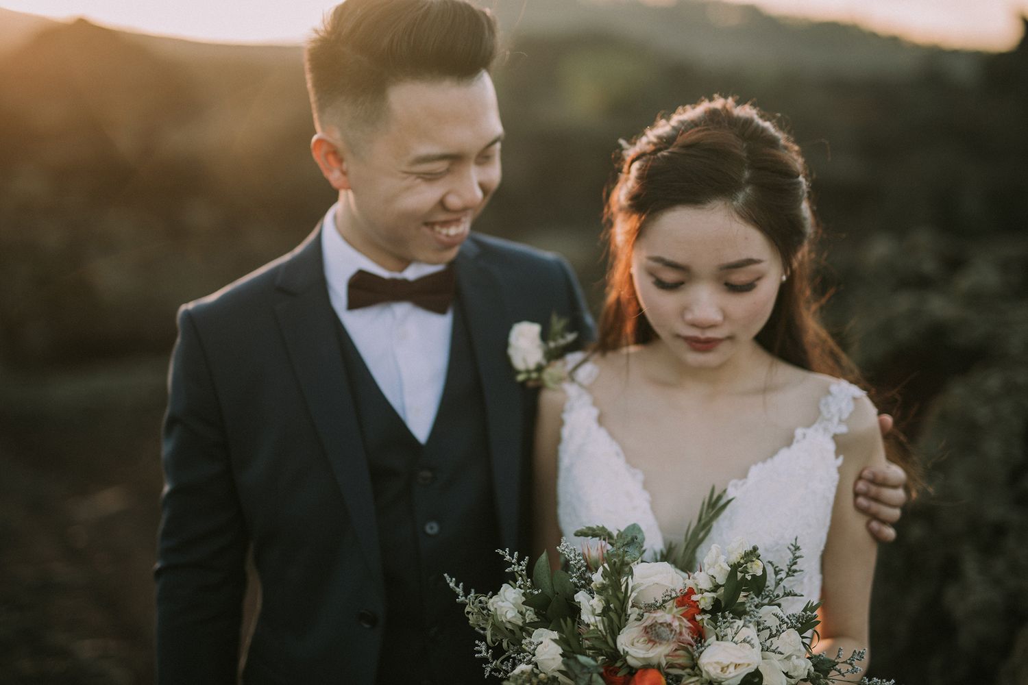 Romantic wedding portraits in front of mountainous terrain at golden hour.