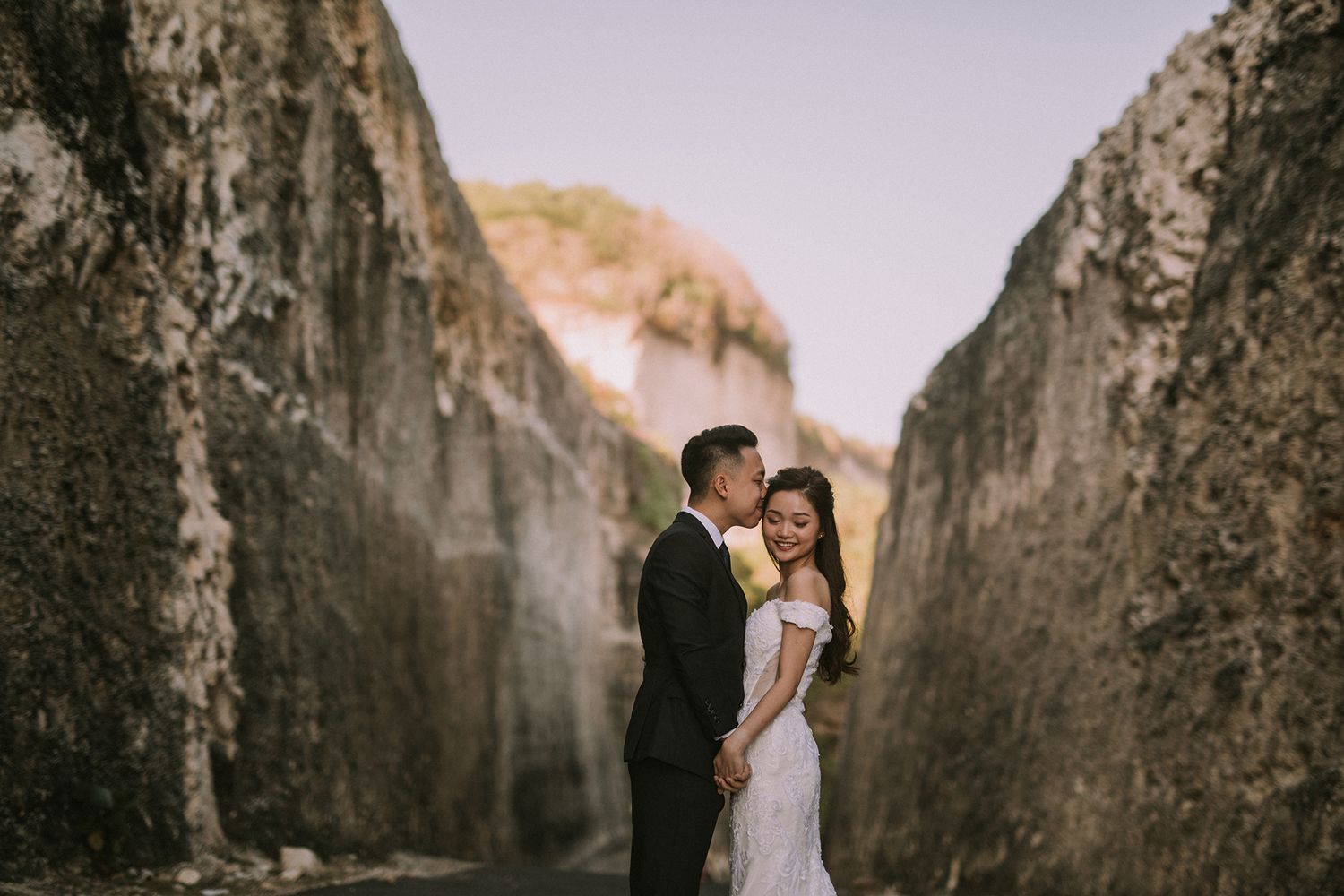 Wedding couple shares intimate moment between towering canyon walls.