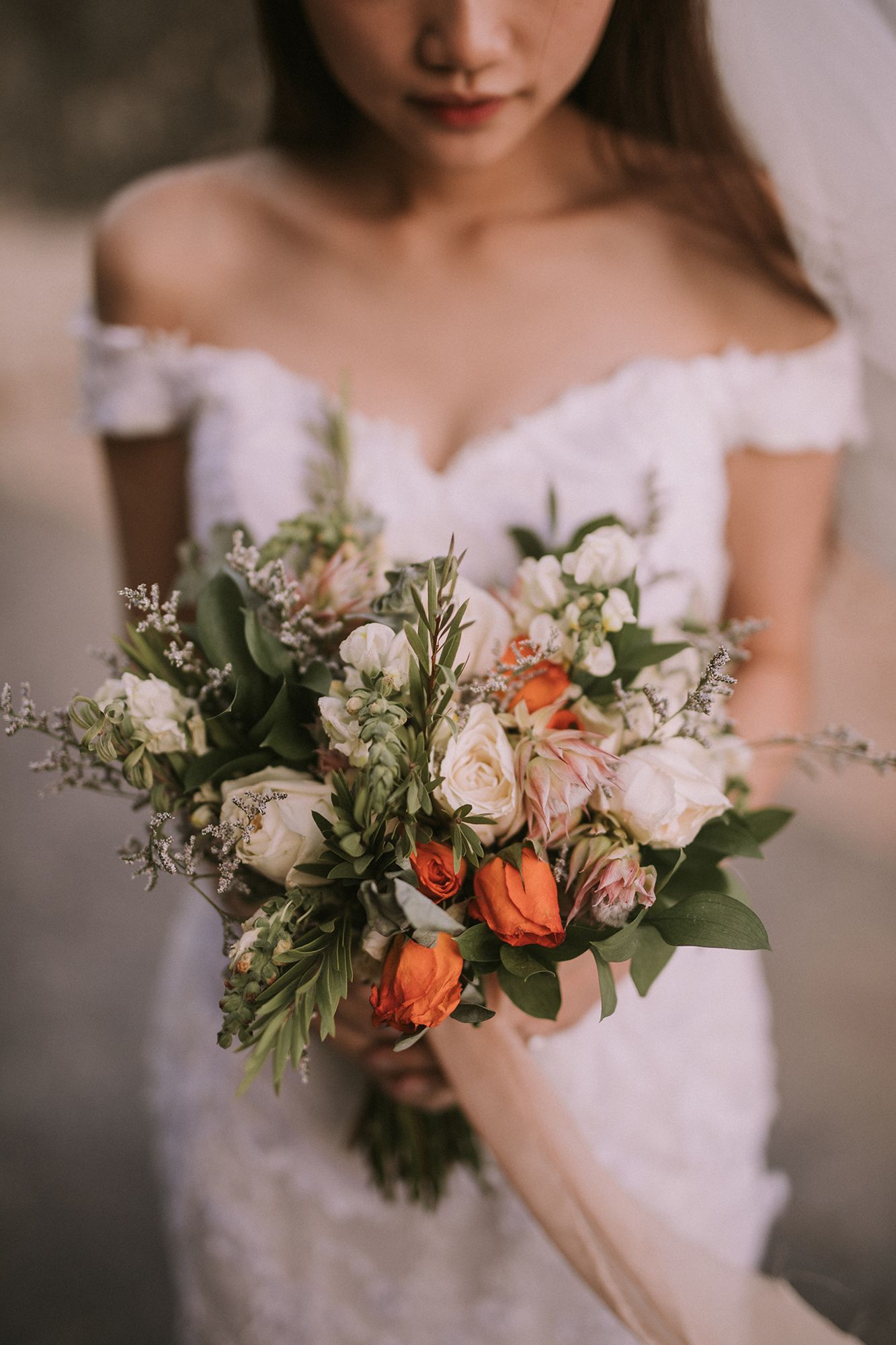 Close-up of delicate bridal bouquet with coral and blush flowers.