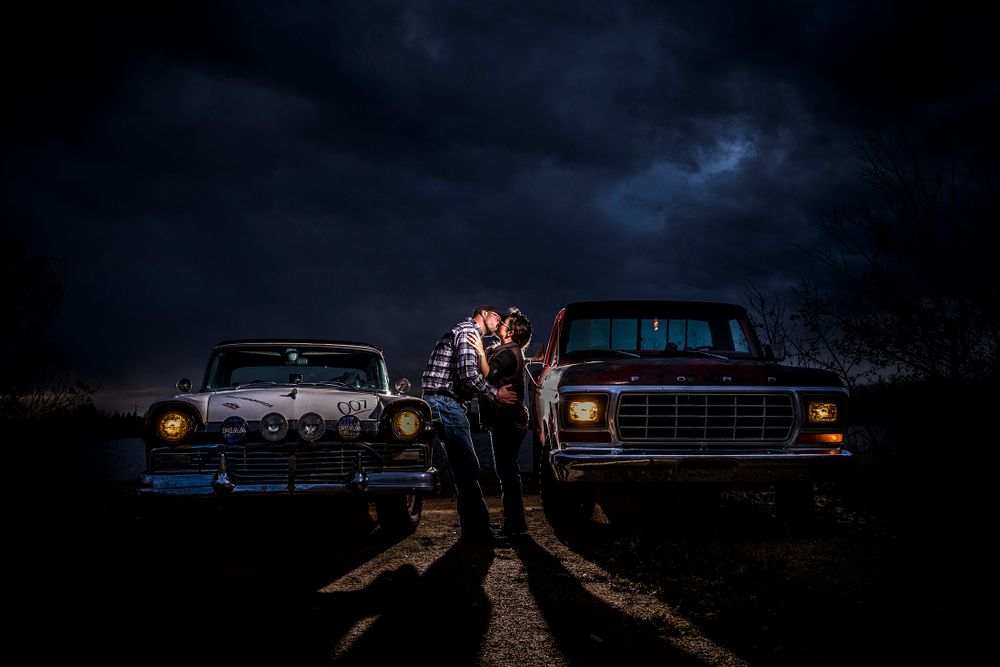 Vintage cars silhouetted against dramatic night sky.