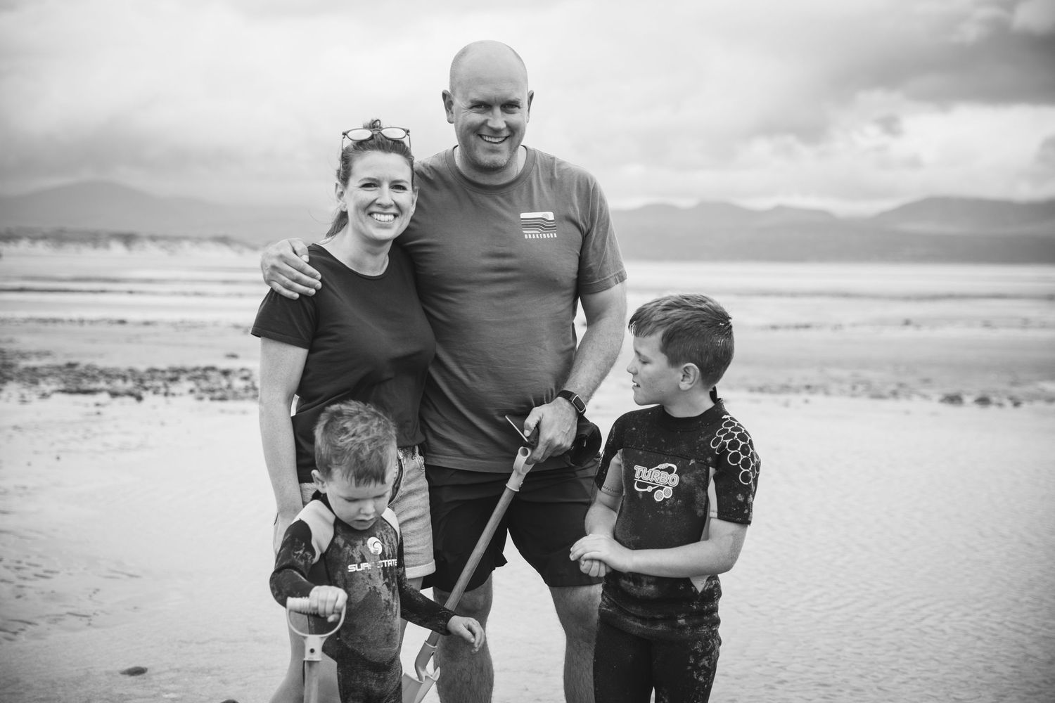Family group enjoying time together on scenic beach landscape.