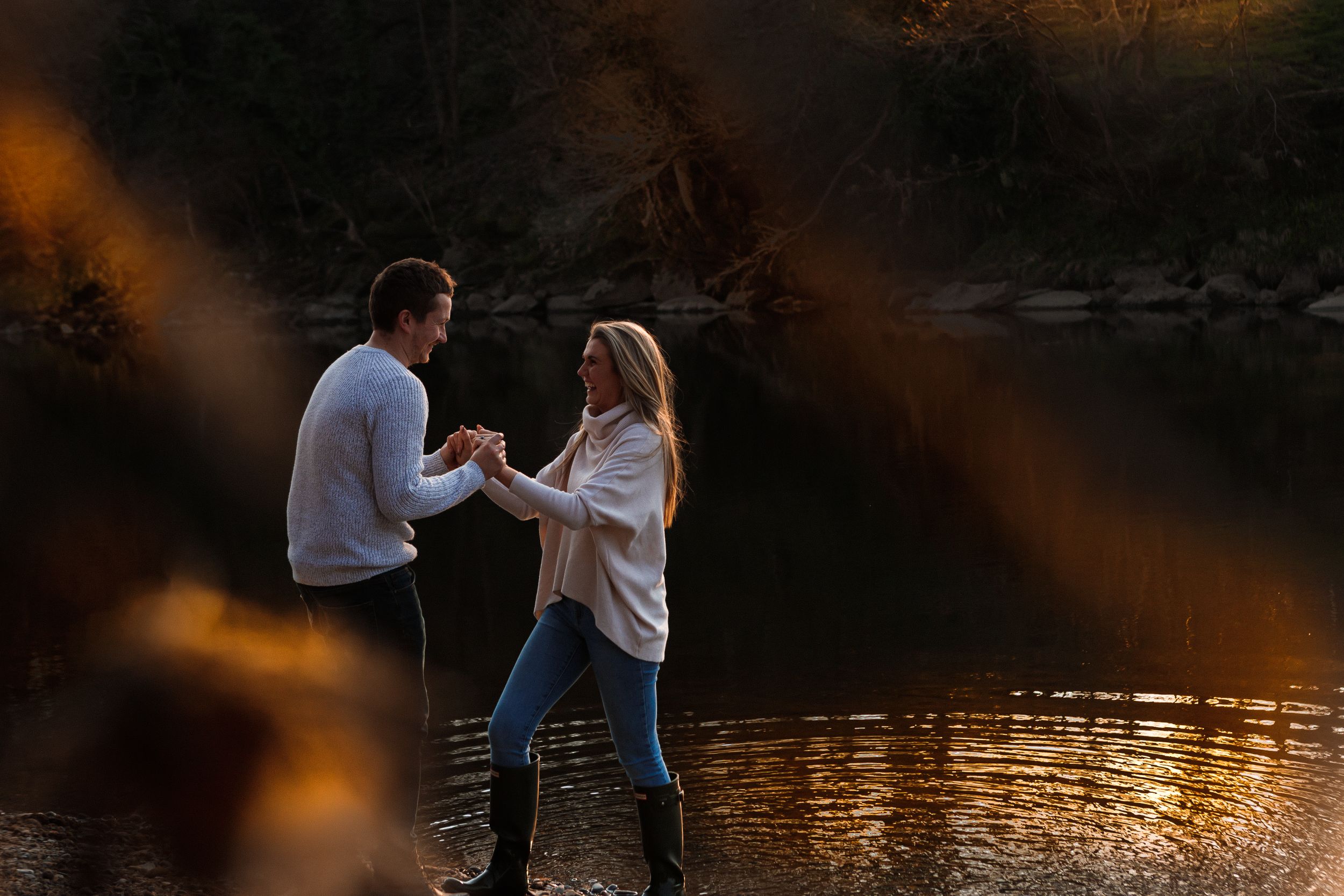 "couple laughing by river engagement shoot"