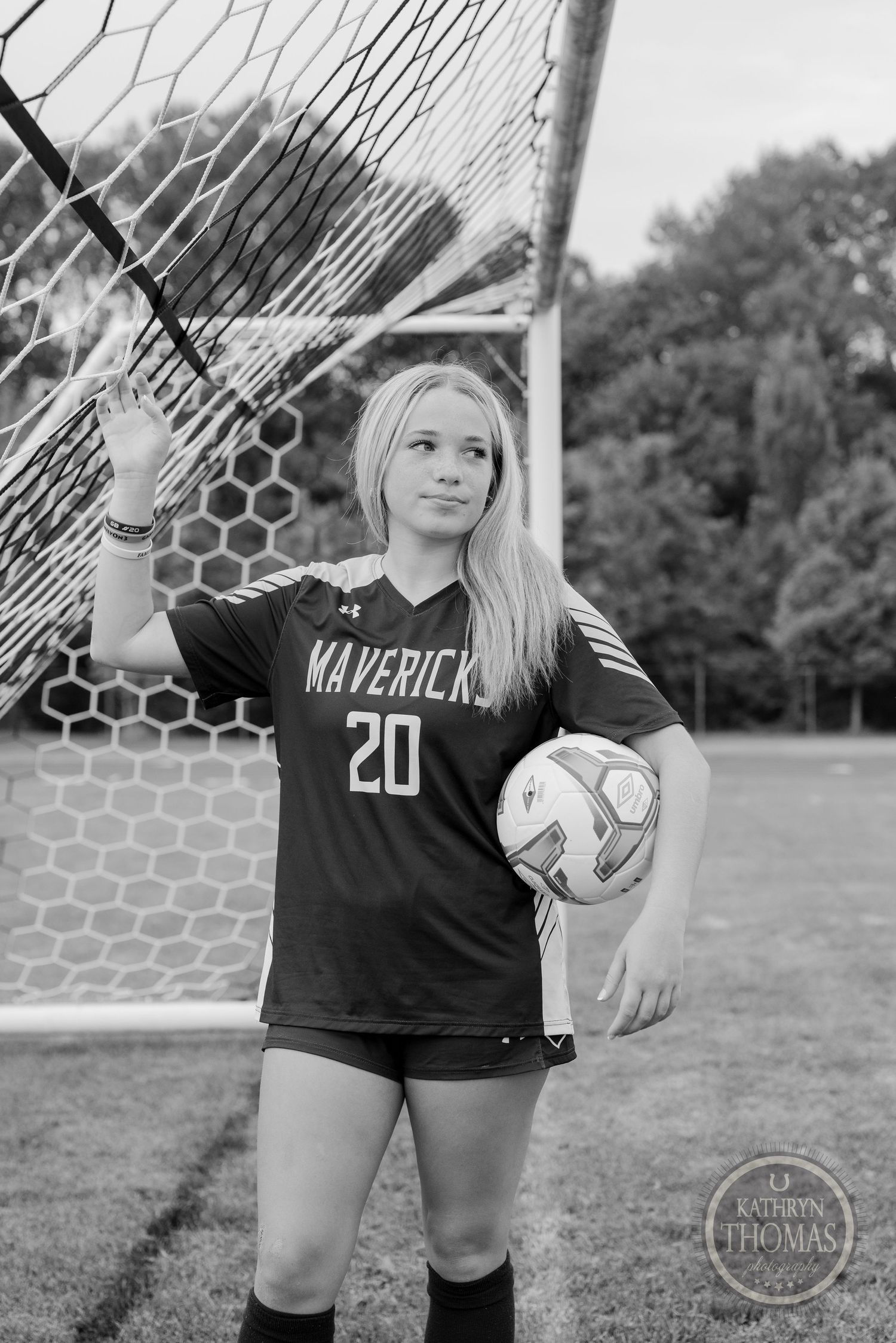 Soccer player in Maverick jersey 20 posing with ball in monochrome.