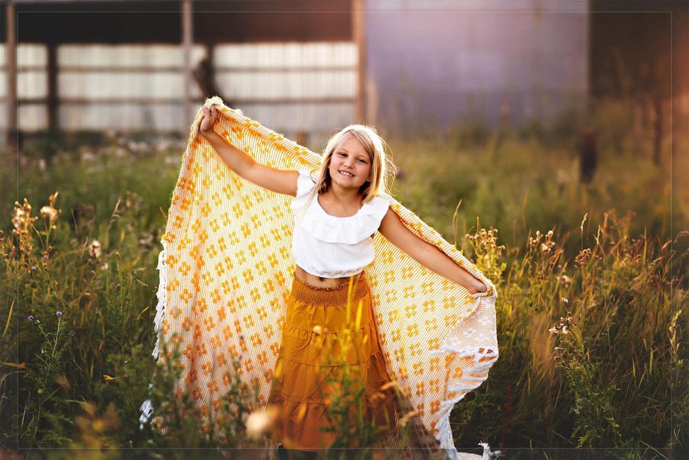 Ethereal outdoor photography with flowing fabric and golden sunset lighting.