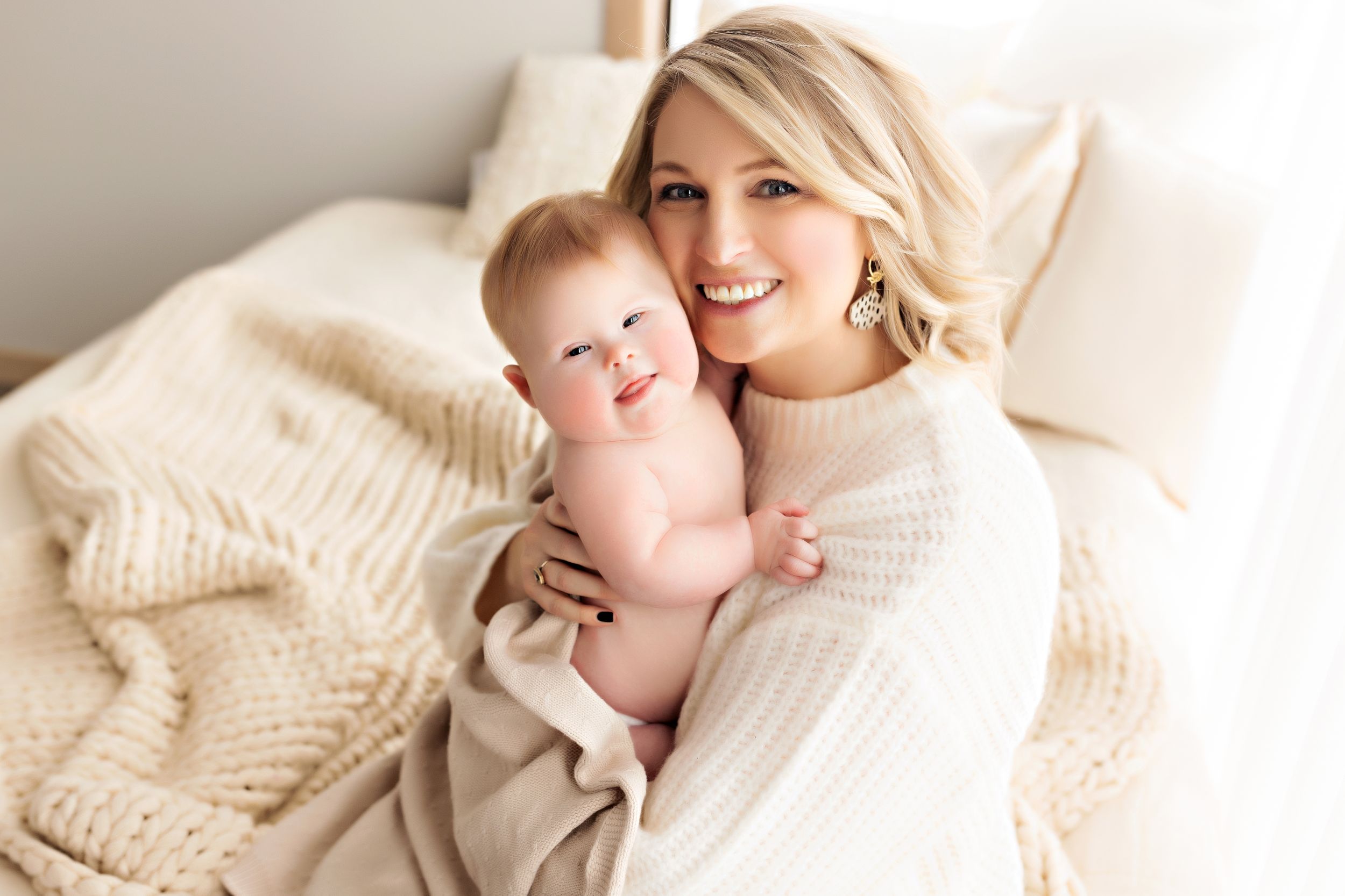 Soft intimate portraits in white knit textures against bright neutral background.
