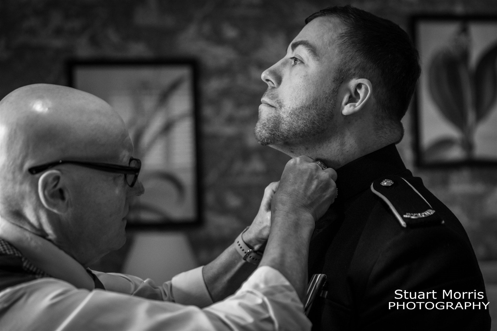 Grooms father helps fasten the grooms top bottom during the wedding prep. Knowsley hall wedding photography.