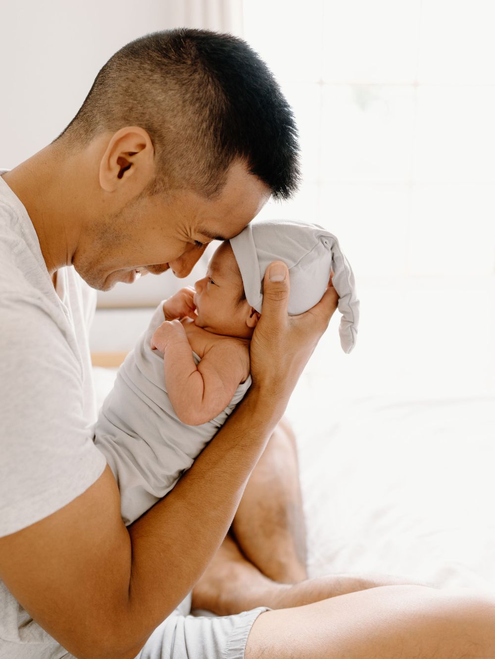 A family photoshoot by Moments With Kell on Oahu in Hawaii with new father looking at his new baby