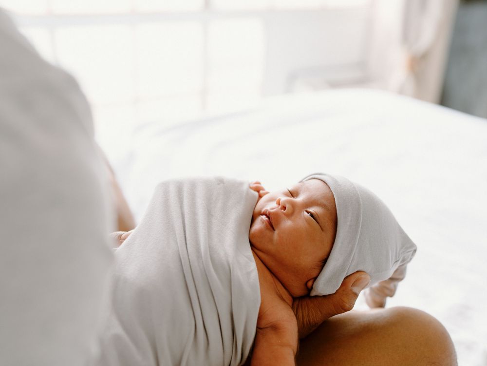 A family photoshoot by Moments With Kell on Oahu in Hawaii with new baby sleeping