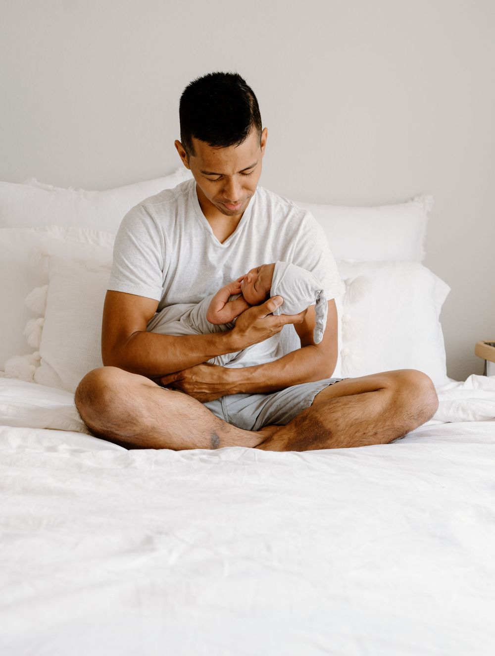 A family photoshoot by Moments With Kell on Oahu in Hawaii with new father looking at his new baby