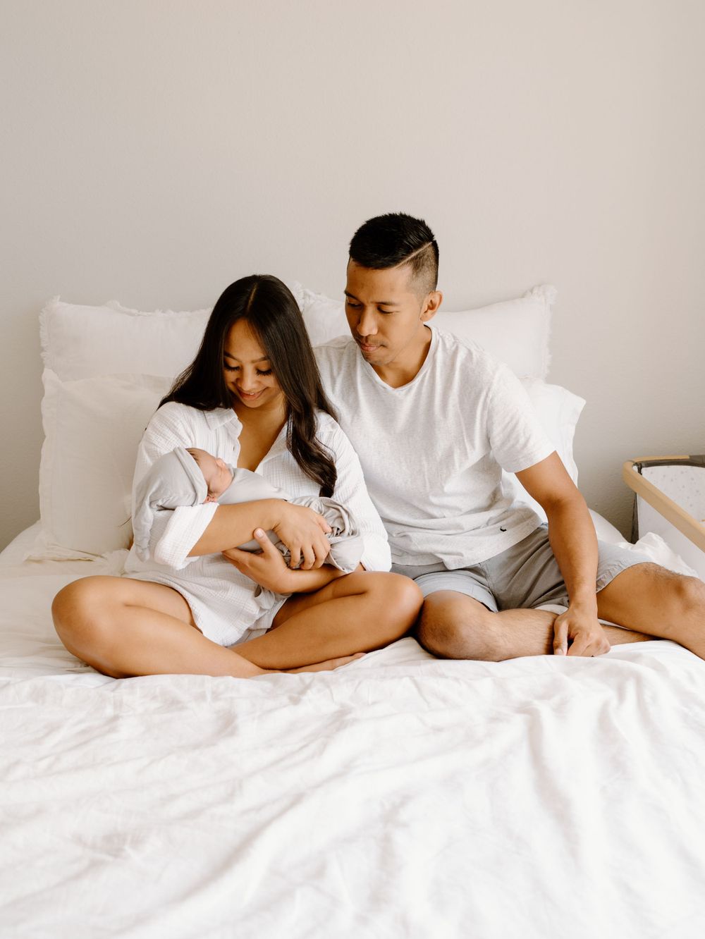 A family photoshoot by Moments With Kell on Oahu in Hawaii with new parents looking at their new baby