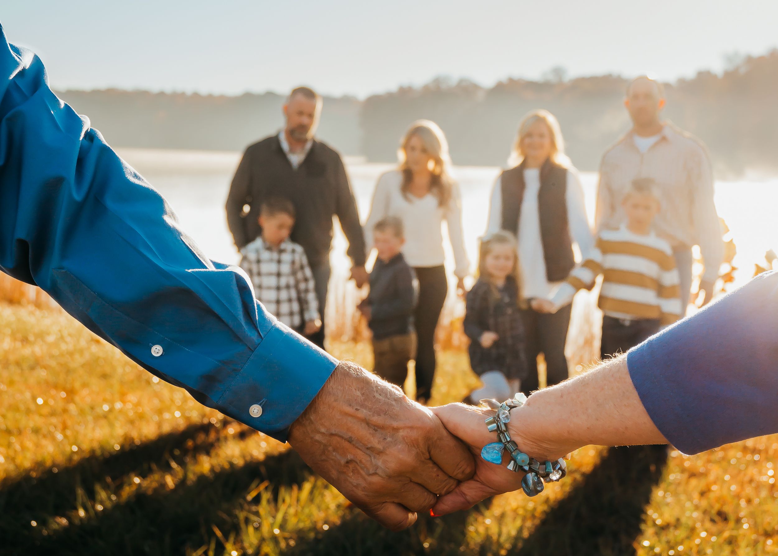 grandparents hold hands in front of the rest of the family during extended family session