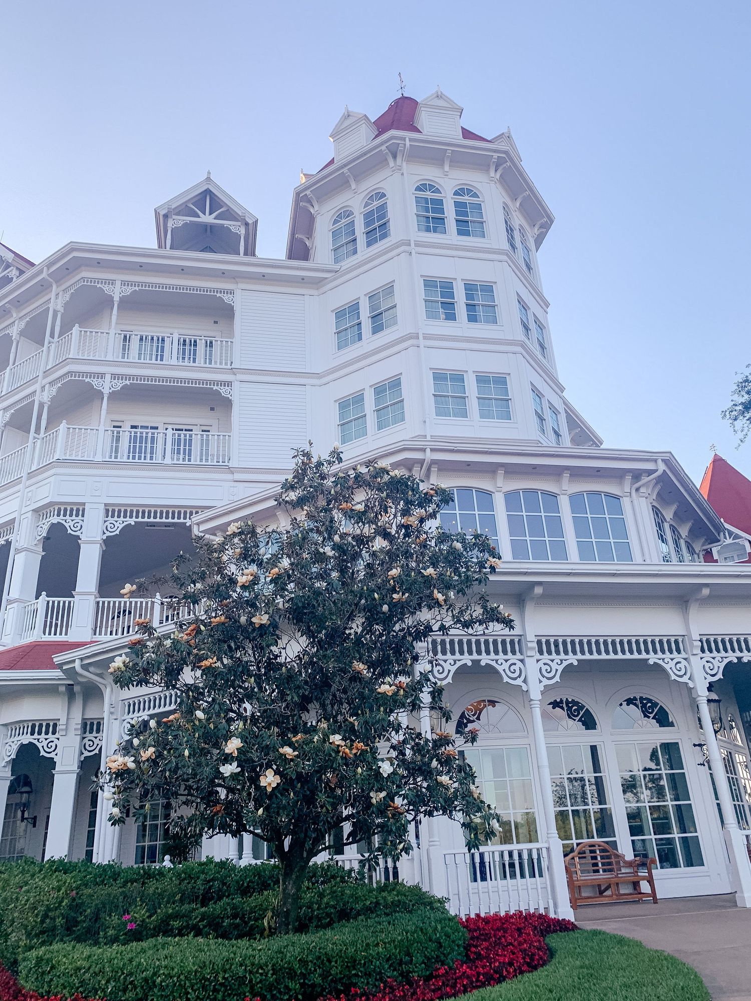 Luxurious white Victorian mansion with ornate balconies and red roof details.