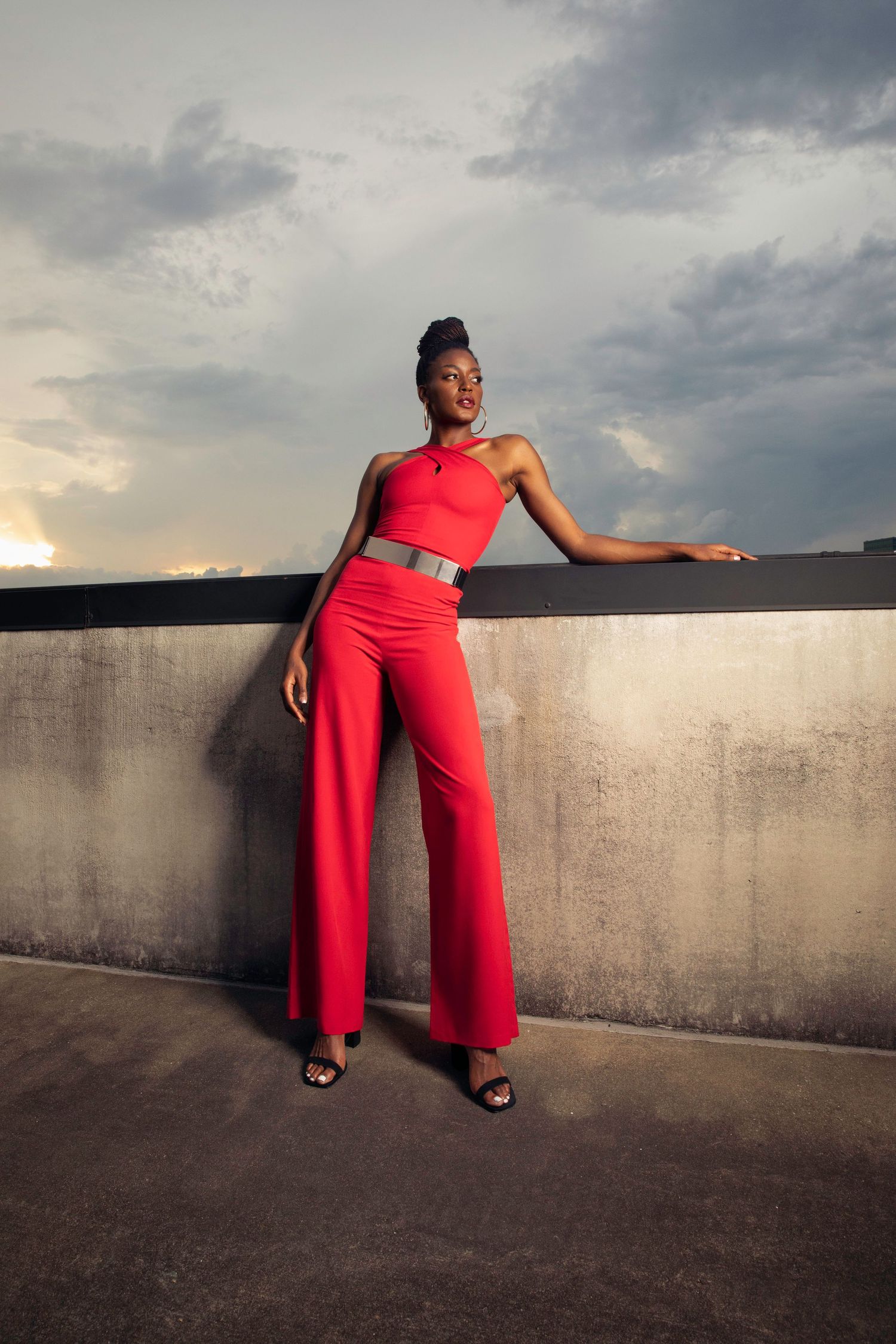 Temi Fagbenle posing in red jumpsuit by model atelier for editorial shoot.