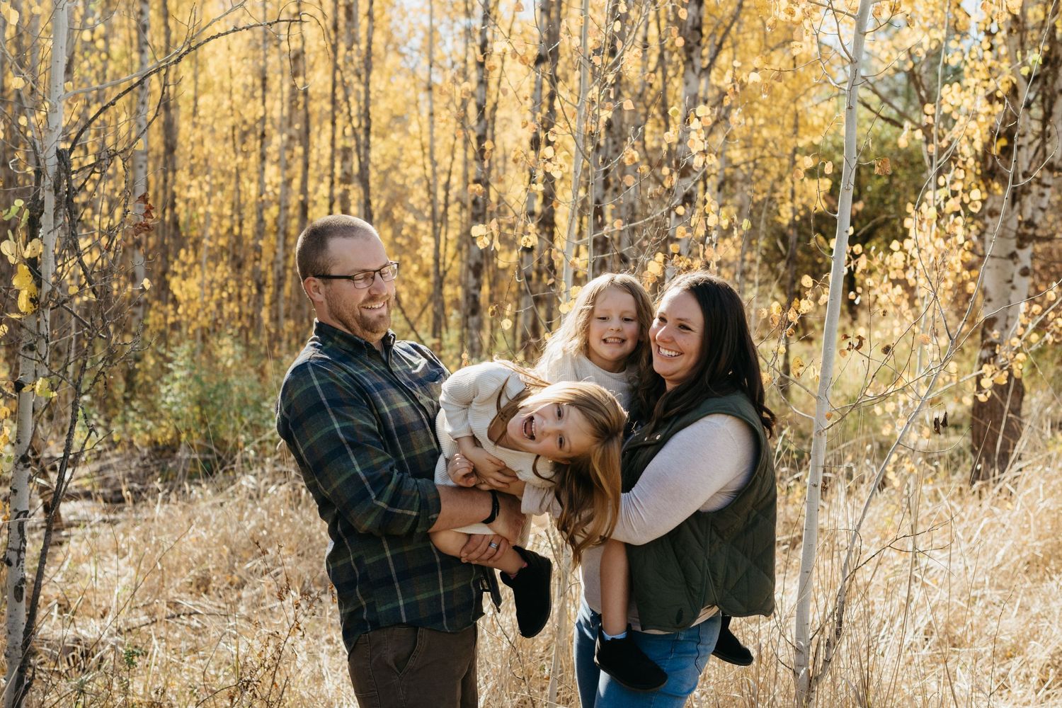 Group enjoying a sunny autumn day in a golden forest with their dog.