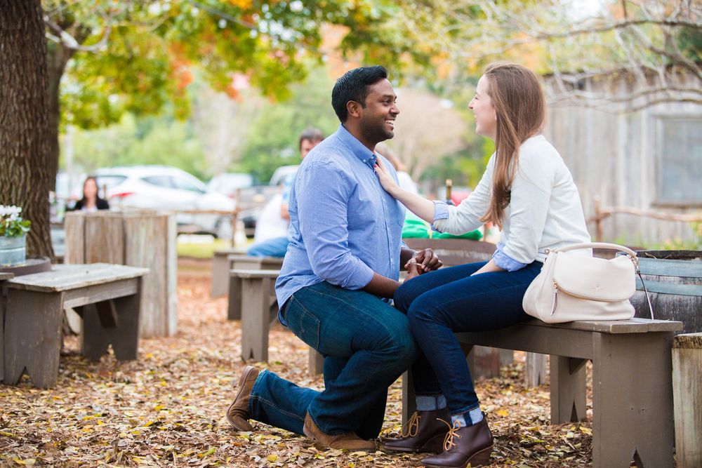 Romantic proposal at an outdoor café as he kneels with a ring