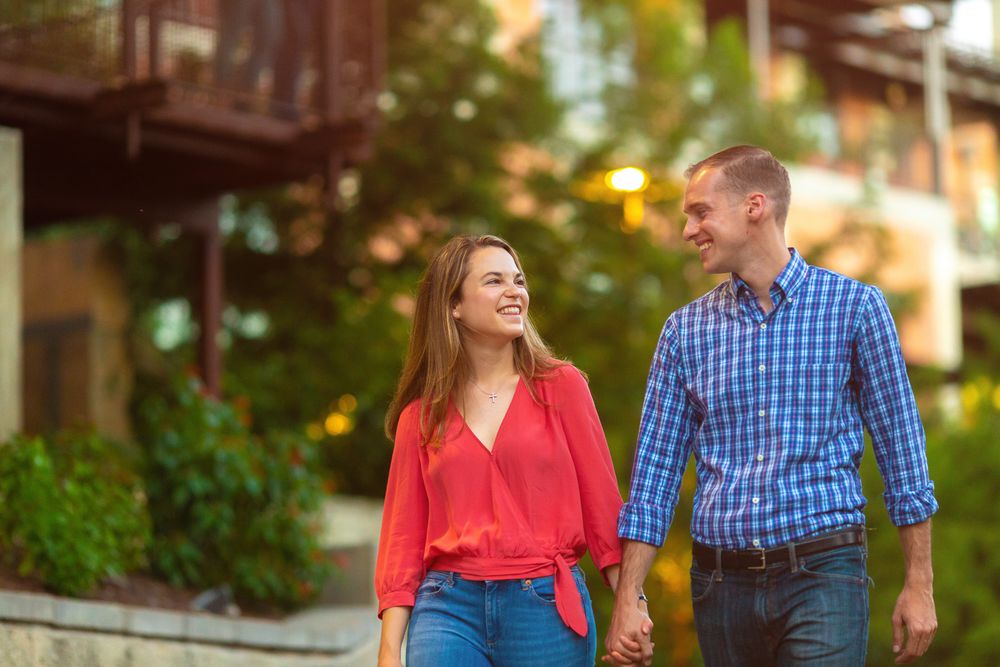 Couple smiling at each other while walking through a charming downtown street