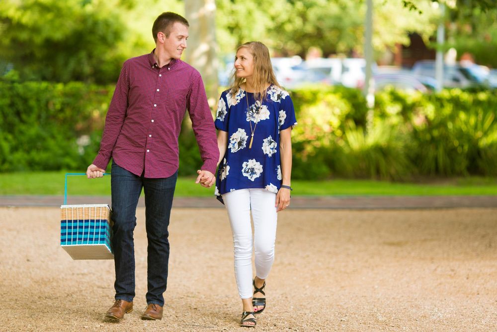 Couple walking hand in hand on a park path — candid engagement portraits in San Antonio