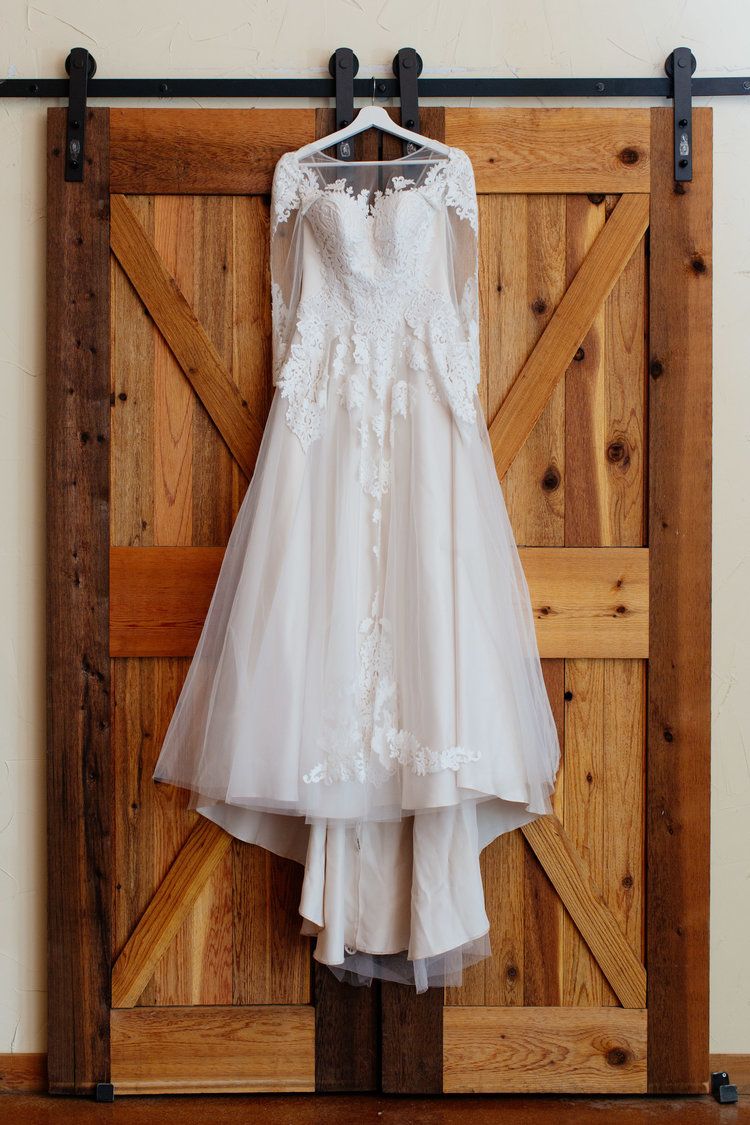 Wedding dress hanging on a wooden door