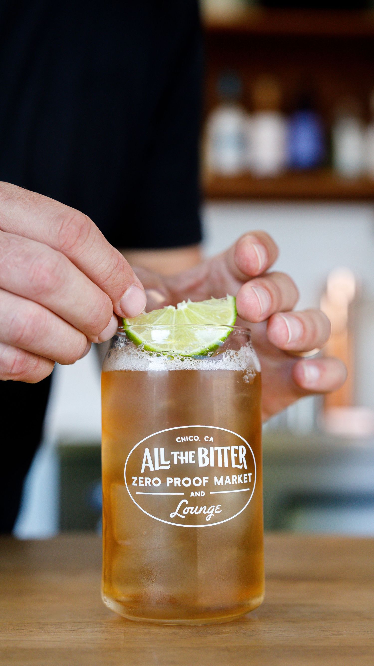 A series of photos showing a cocktail glass being garnished with a lime wedge and salt rim at a lounge bar.