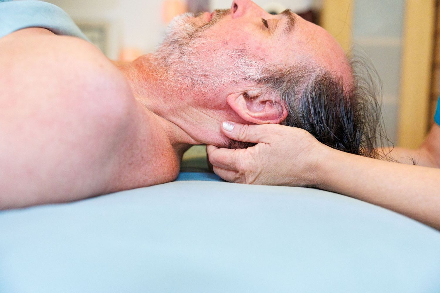A person receives a professional massage therapy treatment on a massage table.
