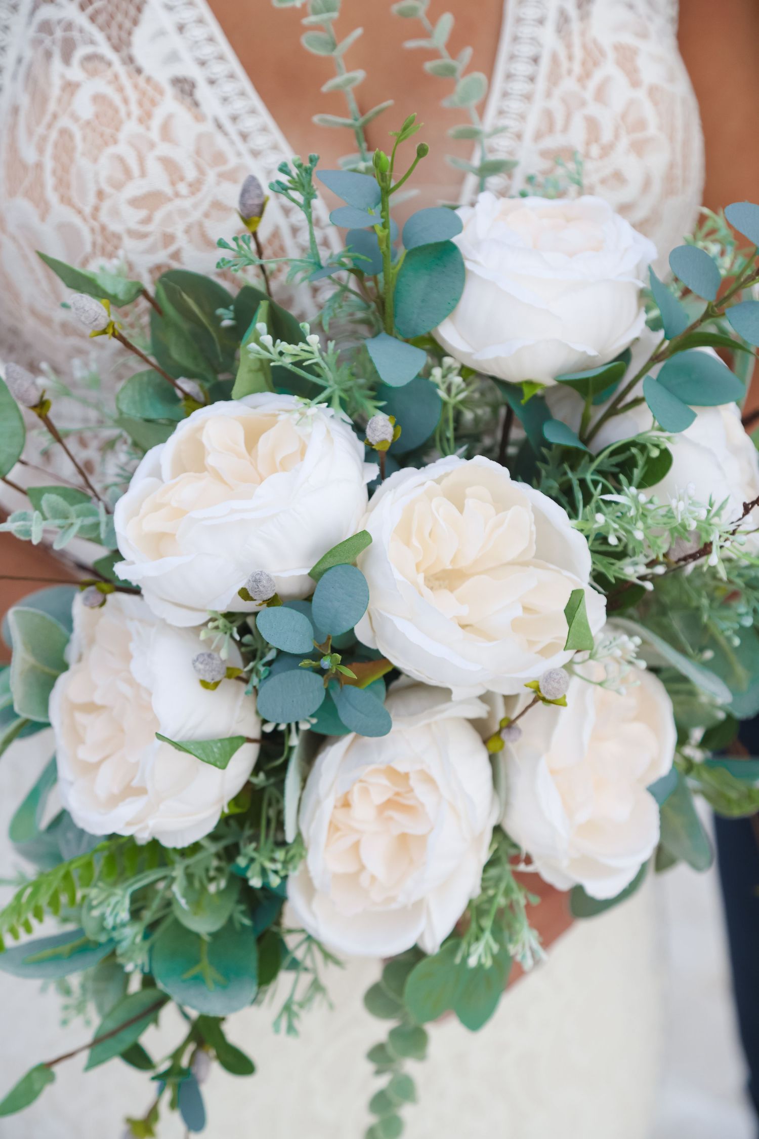 Elegant bridal bouquet featuring white garden roses and eucalyptus greenery.
