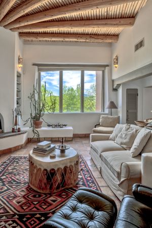Southwestern style living room with wooden beam ceiling and tribal rug decor.