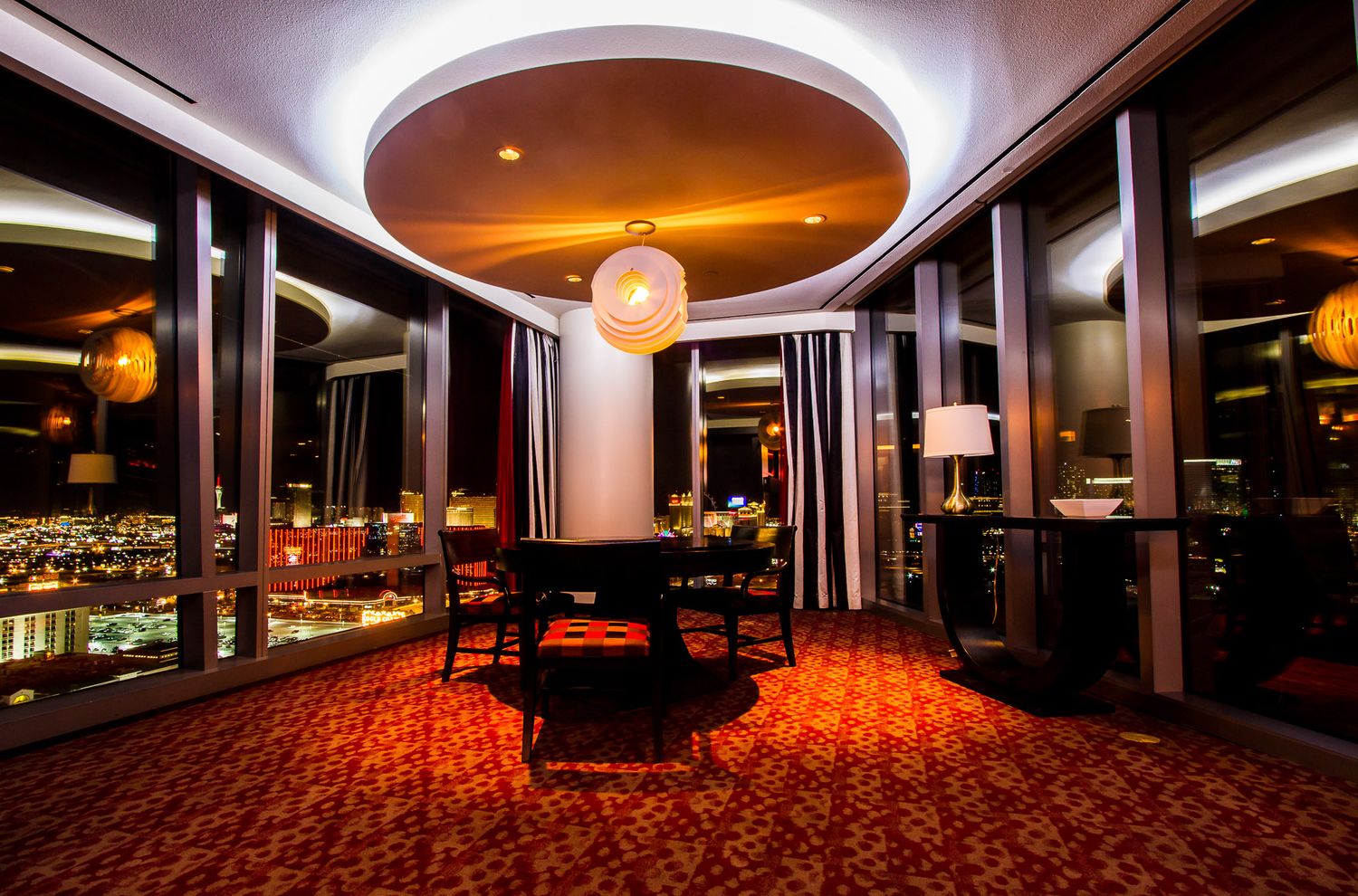Elegant circular dining room with panoramic windows and modern lighting fixtures.