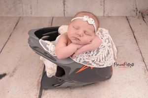 baby carefully posed in dad motorbike helmet