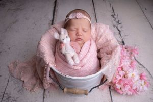simple posed on baby's hand styled with teddy in a sleepy pose in a bucket