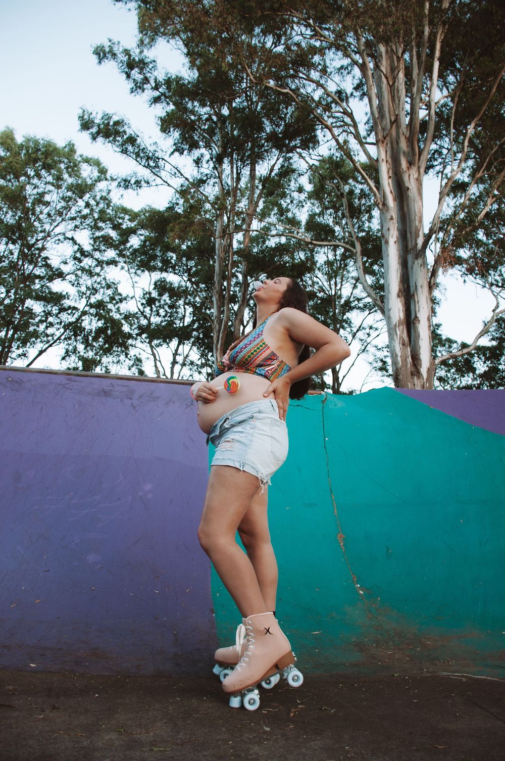 skater maternity photoshoot. mum to be roller skating. 90 style session with lollypops and gum